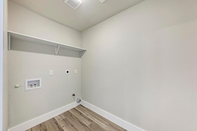 laundry area featuring visible vents, baseboards, light wood-type flooring, gas dryer hookup, and laundry area