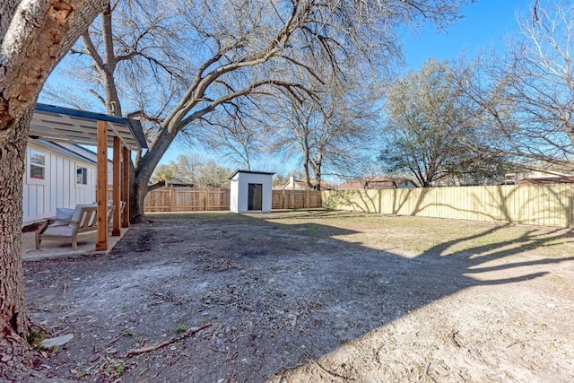 view of yard with an outbuilding, a shed, a patio, and a fenced backyard