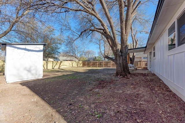 view of yard featuring a fenced backyard, an outdoor structure, and a shed