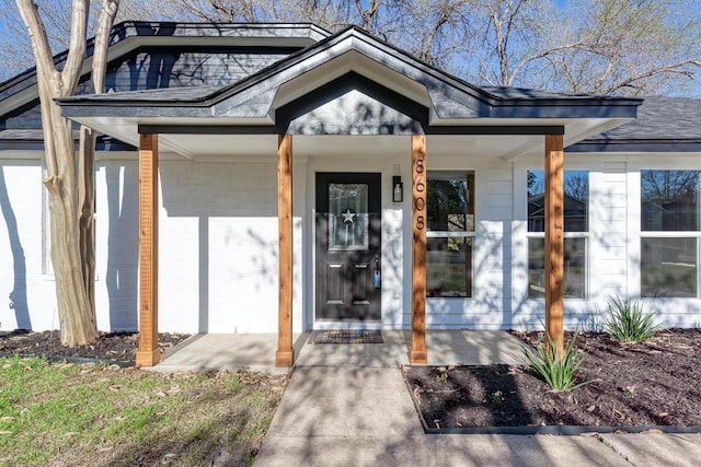 doorway to property featuring a shingled roof