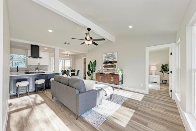 living area featuring light wood-type flooring, visible vents, recessed lighting, baseboards, and vaulted ceiling with beams