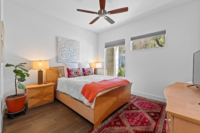 bedroom featuring dark wood-style floors, a ceiling fan, and baseboards