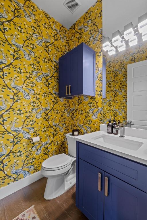 1006 Meriden Ln, Austin, TX 78703 - bathroom featuring wallpapered walls, vanity, and wood finished floors