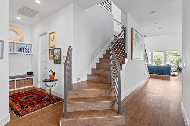 stairs featuring recessed lighting, visible vents, baseboards, and hardwood / wood-style flooring