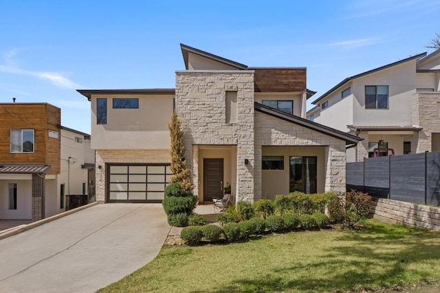 contemporary house featuring stone siding, driveway, an attached garage, and fence