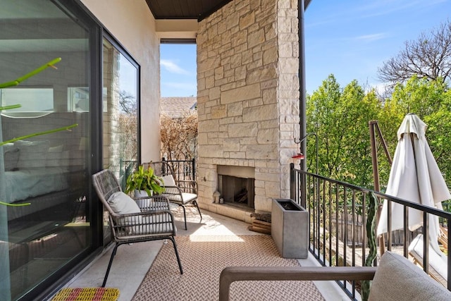 balcony with an outdoor stone fireplace