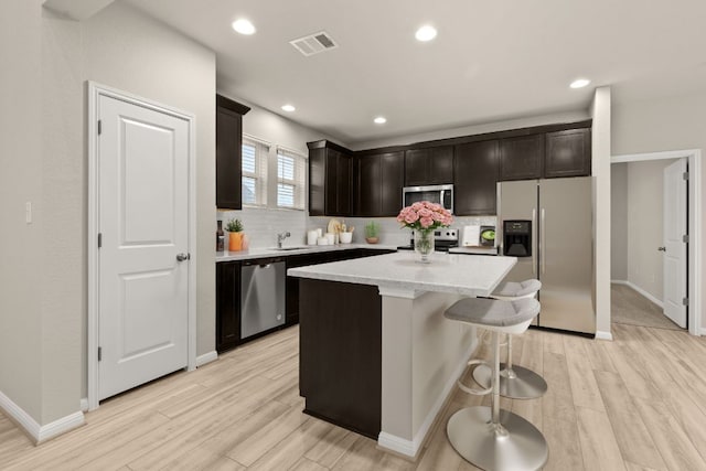 kitchen with tasteful backsplash, light wood-type flooring, visible vents, and stainless steel appliances