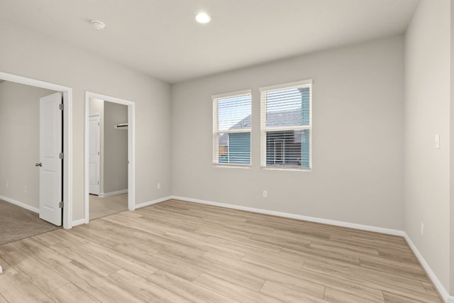 spare room with recessed lighting, baseboards, and light wood-type flooring