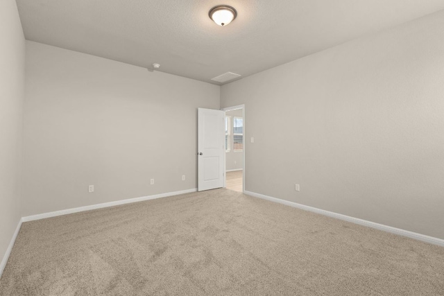 carpeted empty room featuring baseboards and a textured ceiling