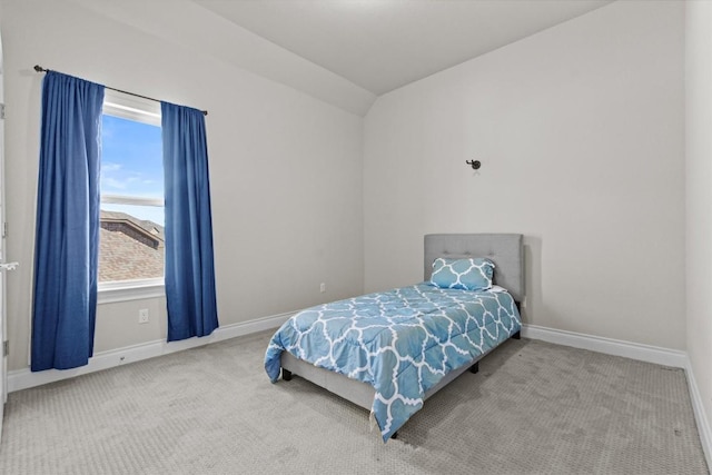 carpeted bedroom featuring baseboards and lofted ceiling