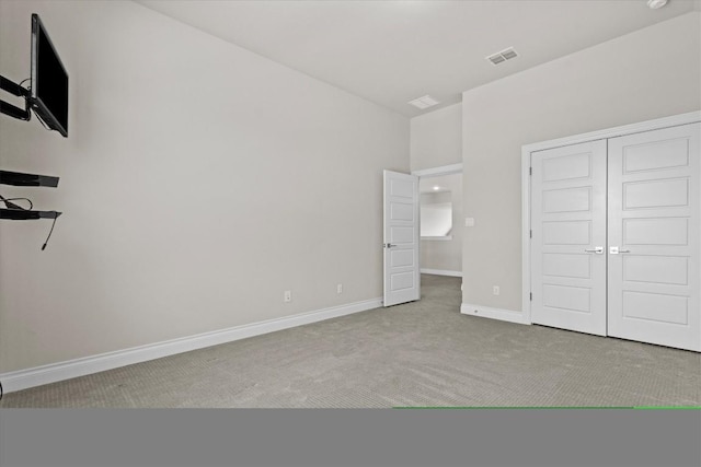 unfurnished bedroom featuring a closet, baseboards, visible vents, and carpet floors