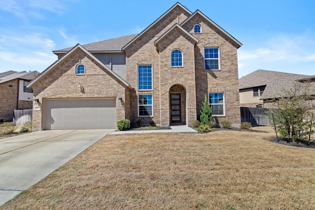 traditional-style house featuring brick siding, a front lawn, fence, a garage, and driveway