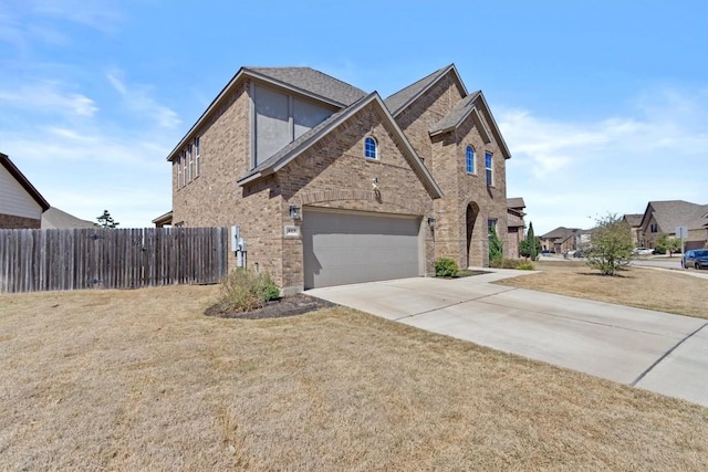 view of front facade featuring a front lawn, brick siding, driveway, and fence