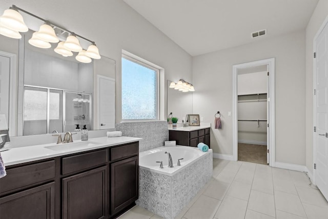 bathroom featuring two vanities, a stall shower, a sink, tile patterned flooring, and a bath