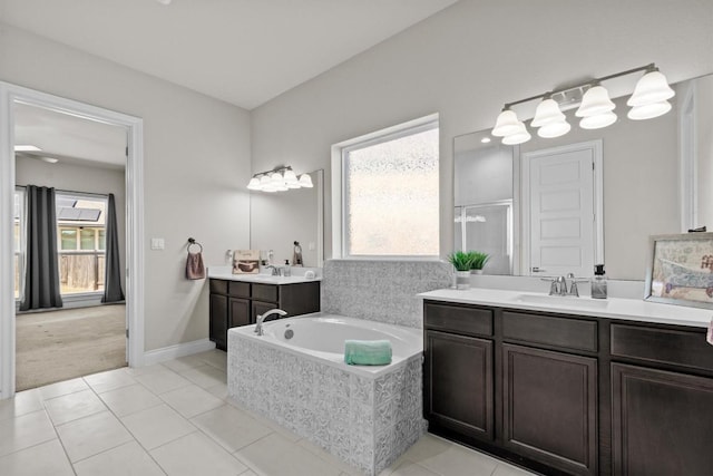 bathroom featuring two vanities, a stall shower, a sink, tile patterned floors, and a bath