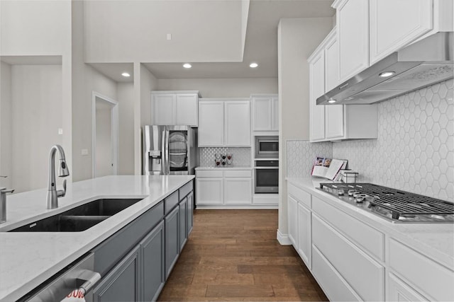 kitchen with a sink, white cabinets, under cabinet range hood, and stainless steel appliances