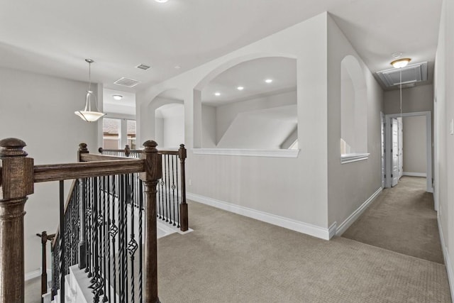 hallway featuring visible vents, an upstairs landing, carpet floors, baseboards, and attic access