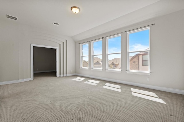 spare room featuring visible vents, baseboards, and light colored carpet