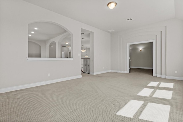 spare room featuring visible vents, recessed lighting, arched walkways, baseboards, and light colored carpet