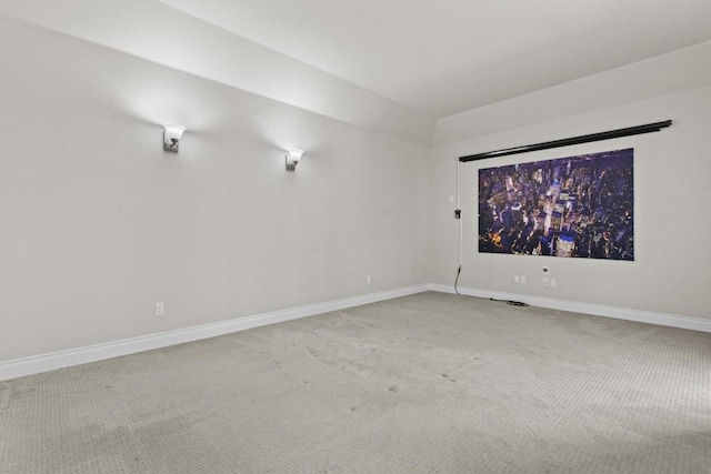 unfurnished room with baseboards and light carpet