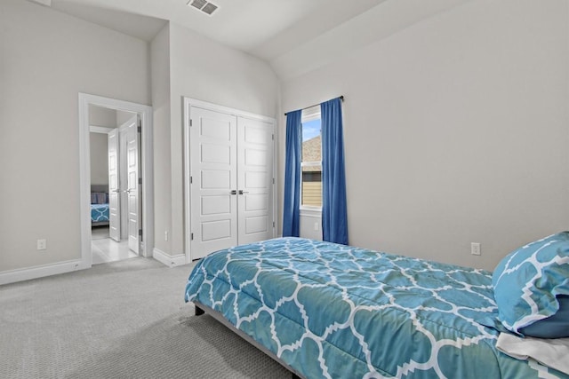 bedroom with carpet, visible vents, baseboards, lofted ceiling, and a closet