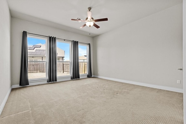 empty room featuring baseboards, carpet floors, and ceiling fan