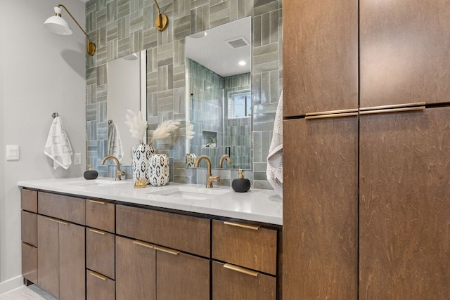 full bath featuring double vanity, visible vents, and a sink