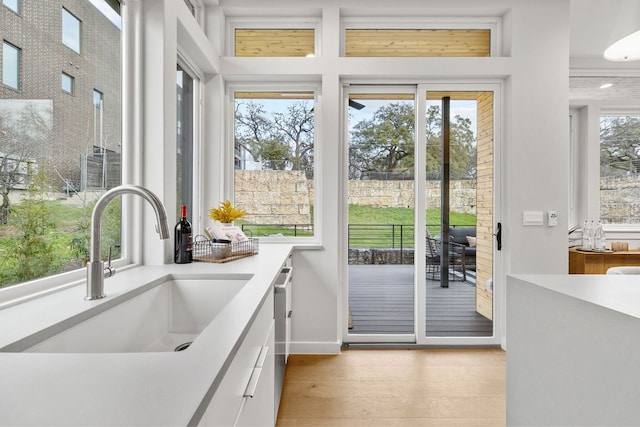 entryway with a sink, light wood-type flooring, and baseboards