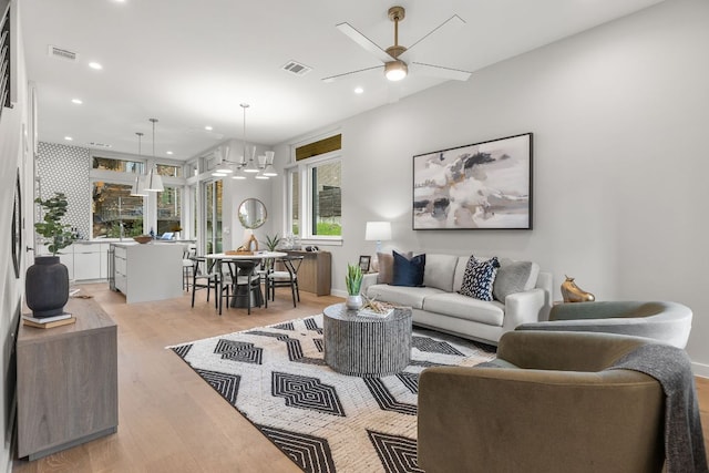 living area with recessed lighting, light wood-style floors, and visible vents