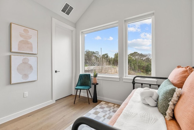 sitting room with visible vents, baseboards, lofted ceiling, and wood finished floors