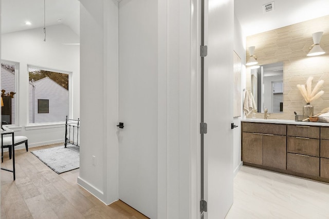 bathroom with visible vents, backsplash, recessed lighting, lofted ceiling, and vanity