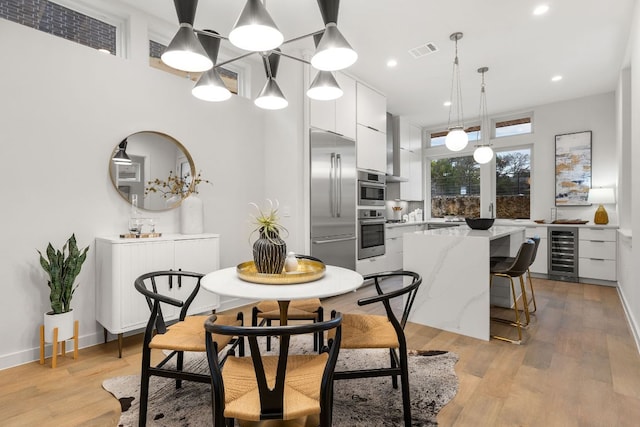 dining space featuring wine cooler, visible vents, recessed lighting, and light wood-style floors