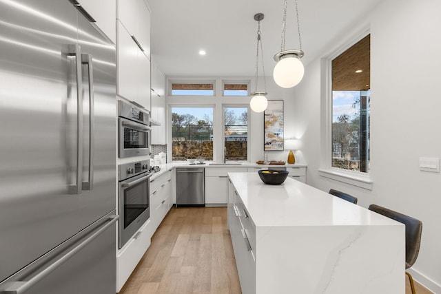 kitchen featuring white cabinets, modern cabinets, a kitchen island, and stainless steel appliances