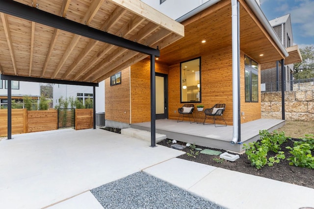 view of patio / terrace featuring a porch, central air condition unit, and fence