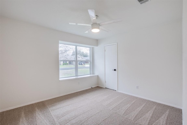 empty room with a ceiling fan, baseboards, and light carpet