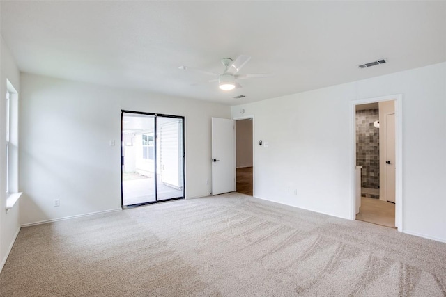 spare room featuring light carpet, visible vents, and ceiling fan