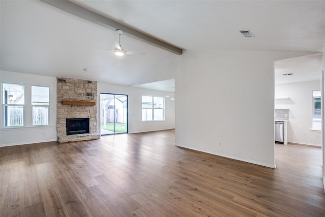 unfurnished living room featuring a ceiling fan, a stone fireplace, wood finished floors, and vaulted ceiling with beams