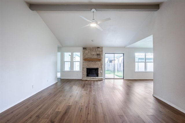 unfurnished living room featuring beamed ceiling, high vaulted ceiling, a ceiling fan, dark wood finished floors, and a stone fireplace