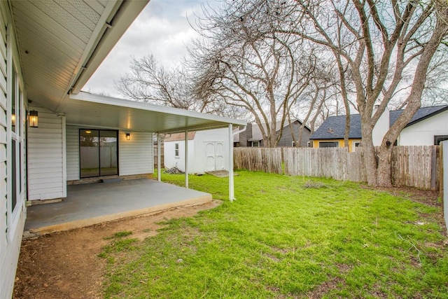 view of yard featuring a patio, a storage unit, fence, and an outdoor structure