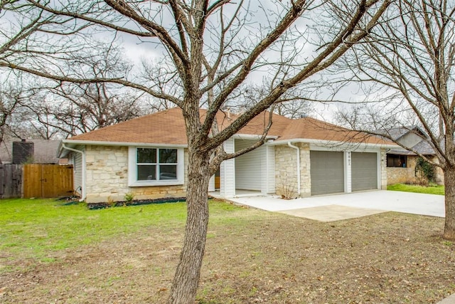 view of front of house featuring stone siding, an attached garage, driveway, and fence