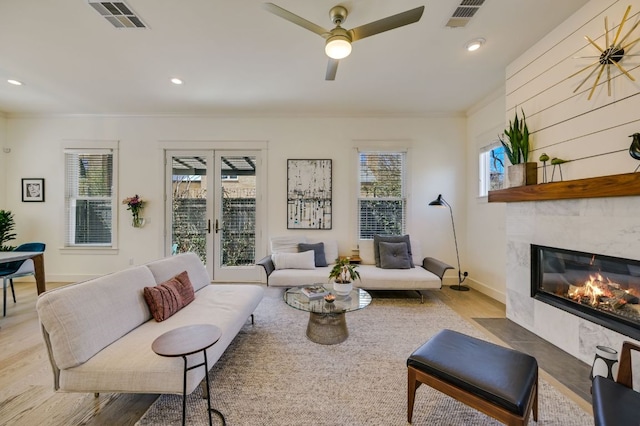 living room with visible vents, a fireplace, crown molding, and french doors