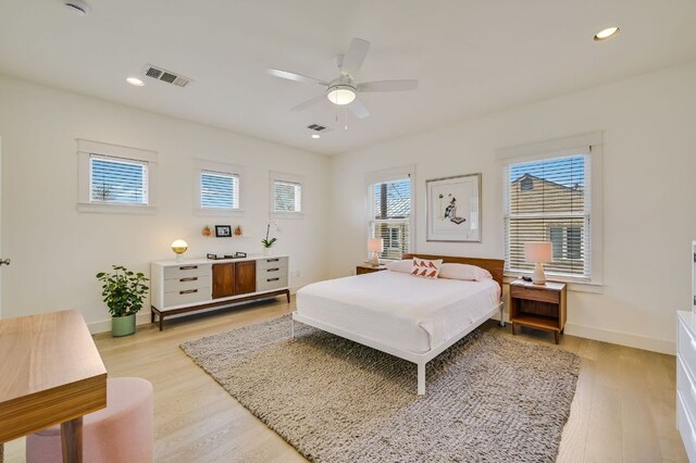 bedroom with light wood-style floors, visible vents, and baseboards