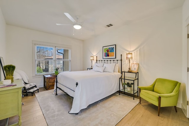 bedroom with visible vents, baseboards, wood finished floors, and a ceiling fan