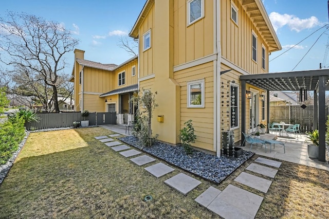 view of property exterior featuring board and batten siding, a patio, and fence