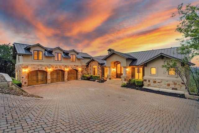 view of front of home with stone siding, stucco siding, metal roof, and a standing seam roof