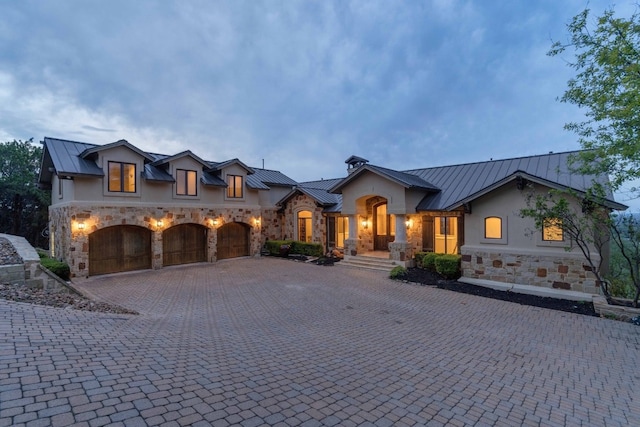 9104 Atwater Cv, Austin, TX 78733 - view of front of property featuring a standing seam roof, metal roof, stone siding, decorative driveway, and stucco siding