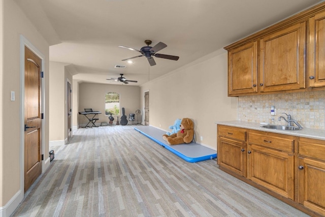 9104 Atwater Cv, Austin, TX 78733 - kitchen featuring a sink, brown cabinetry, baseboards, and ceiling fan
