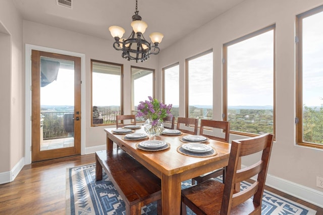 9104 Atwater Cv, Austin, TX 78733 - dining area with wood finished floors, a chandelier, and baseboards