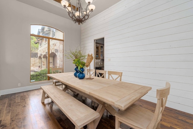 9104 Atwater Cv, Austin, TX 78733 - dining space with a chandelier, wood finished floors, baseboards, and wood walls