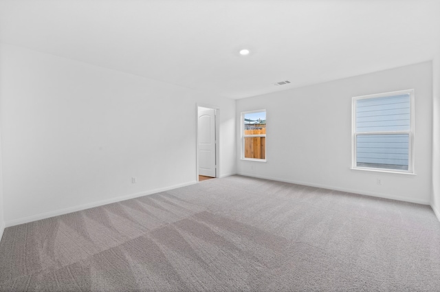 carpeted empty room featuring visible vents, recessed lighting, and baseboards